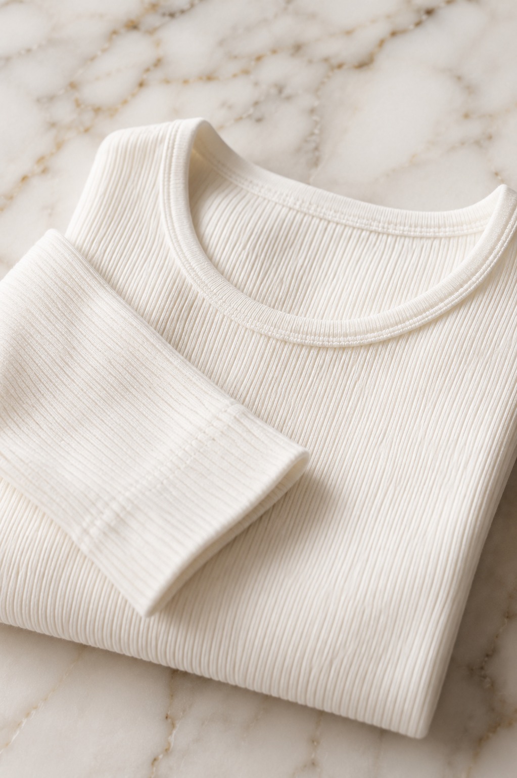 Close-up de blusa branca canelada de manga longa, a camada base perfeita para o inverno